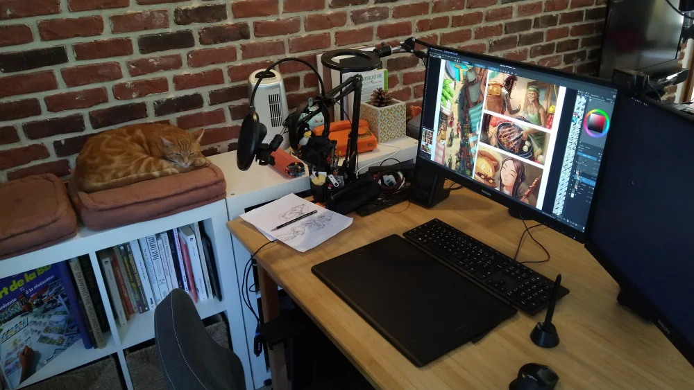 Grafiskā planšete ar pildspalvu mākslinieka darba vietā pie monitora